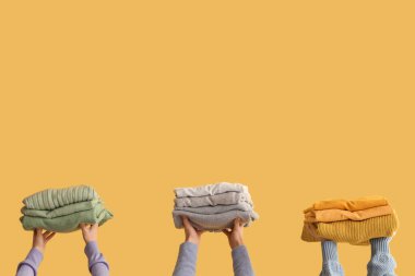 Sarı arka planda katlanmış süveterli kadınlar