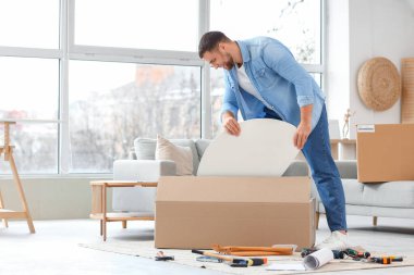 Young man assembling table at home
