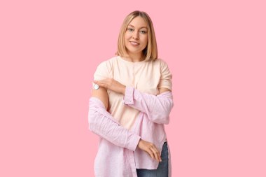 Kan şekeri seviyesini pembe arka planda ölçmek için glikoz sensörü olan bir kadın. Diyabet kavramı