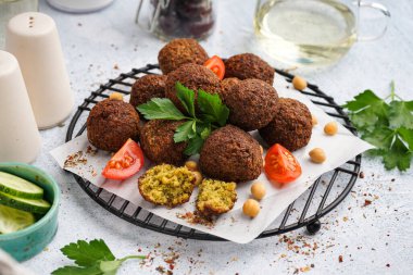 Hafif arkaplanda nefis falafel topları, nohut ve domatesin yanında dur.