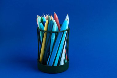 Mavi arkaplanda farklı kalemler bulunan şık tutucu