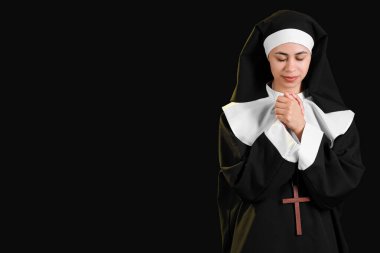 Siyah arka planda dua eden genç bir rahibe