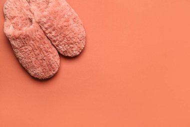 Kırmızı arka planda bir çift kırmızı yumuşak terlik. Üst görünüm