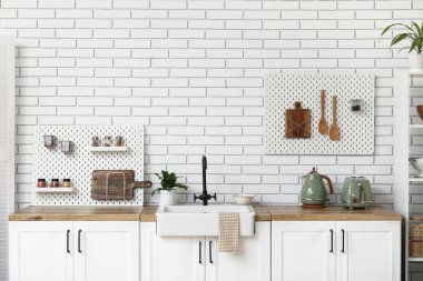 Tahta ve mutfak gereçleri olan şık bir mutfak.