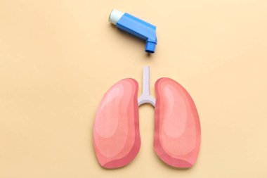 Bej arka planda astım spreyi ve kağıt ciğerler