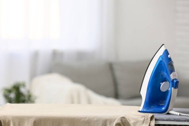 Mavi ütü ve giysiler odada.