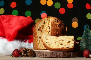 Kesik Panettone ahşap tahta ve koyu bulanık arka planda Noel dekoru