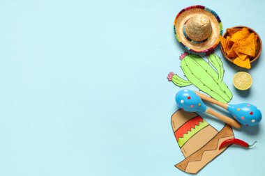 Meksika marakası, sombrero, nachos ve mavi arka planda kağıt dekor. Cinco de Mayo