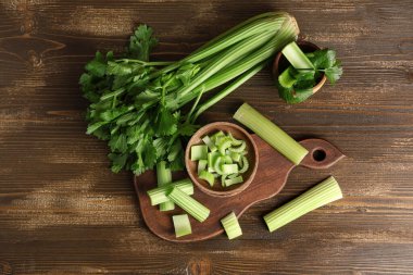 Ahşap zemin üzerinde taze yeşil kereviz kesilmiş yemek ve kaseler.