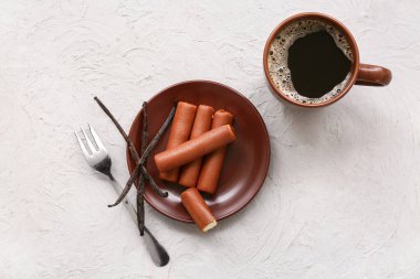 Gri grunge arka planda vanilyalı lezzetli peynirli bir fincan kahve ve tabak.