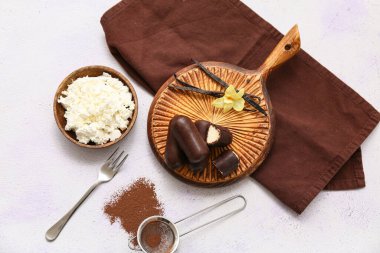 Bir kase kaymak, toz kahve ve beyaz arka planda lezzetli süzme peynirli barlar.