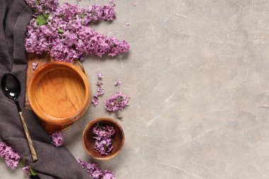 Gri grunge arka planında leylak çiçekleri olan güzel bir masa.