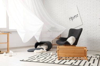 Koltuklu dağınık oturma odası ve ters çevrilmiş kahve masası.