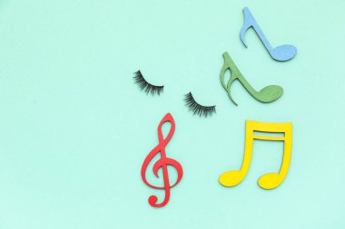 Renk arkaplanı üzerine takma kirpikli kompozisyon ve kağıt not tabelaları