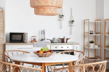 Yemek masası, sandalyeler ve lamba şık bir mutfakta.