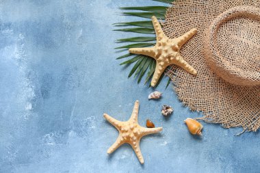 Şapkalı, deniz kabuklu ve mavi grunge arka planda deniz yıldızlı güzel bir kompozisyon.
