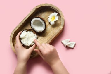 Hindistancevizi ezmeli, kabuklu kadın elleri ve pembe arka planda bir çiçek.