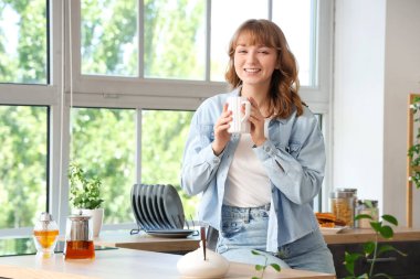 Mutfakta çay içen bir kadın.