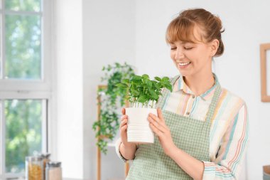 Mutfakta fesleğen bitkisi olan kadın