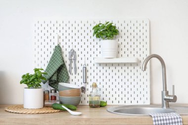 Mutfaktaki masada tas, baharat ve salatalıklı fesleğen.