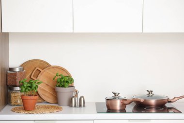 Mutfaktaki mutfak masasında çatal bıçaklı fesleğen bitkileri