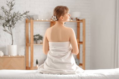 Kaplıca salonunda dinlenen genç bir kadın.