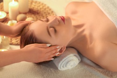 Kadın güzellik salonunda yüz masajı yaptırıyor.