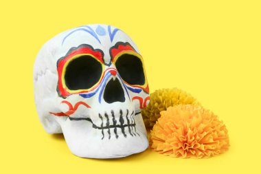 Meksika Ölüler Günü için boyanmış kafatası (El Dia de Muertos) ve sarı arka planda kadife çiçekleri