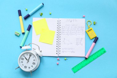 Alarmlı defter ve mavi arkaplanda okul kırtasiyesi