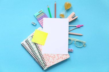 Mavi arkaplanda gözlüklü ve okul kırtasiyeli defter