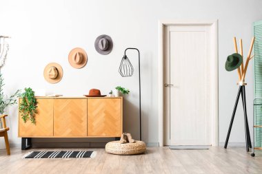 Ahşap klozet, elbise askısı ve şapkası olan modern koridor.