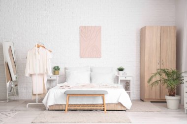 Aydınlık yatak odasının şık ve temiz kıyafetleri var.