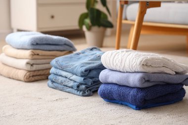 Odada yerde yığınla temiz giysi var.