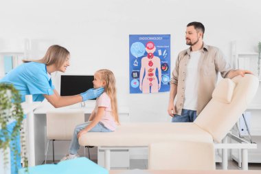 Tiroid bezini inceleyen kadın endokrinolog ve babası klinikte.