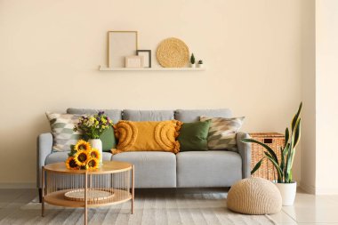 Oturma odasındaki sehpada rahat bir kanepe ve yabani çiçekler.