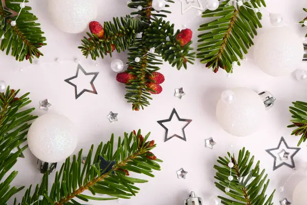 Noel toplarıyla kompozisyon, beyaz arka planda böğürtlenli köknar dalları ve yıldızlarla