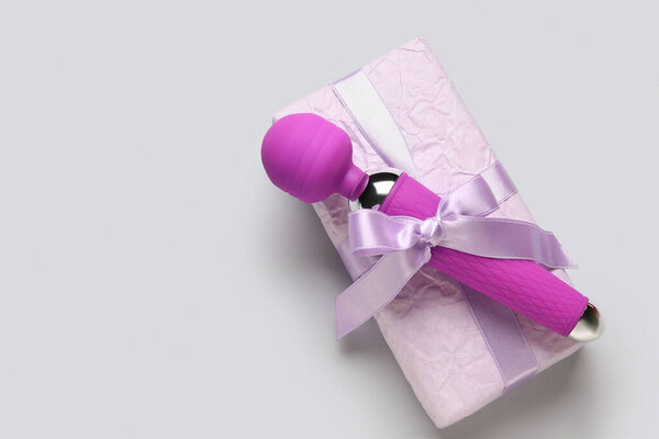 Clitoral vibrator and gift box on grey background
