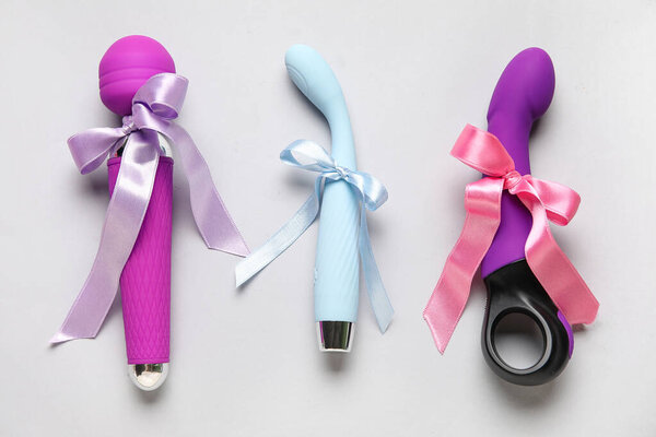 Different sex toys as gift on grey background
