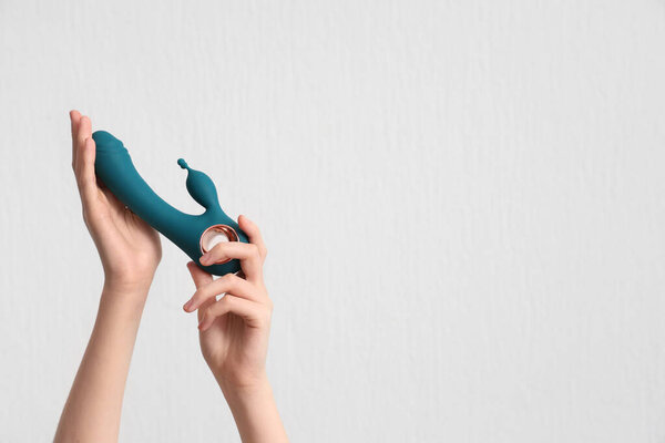 Женские руки с вибратором на белом фоне