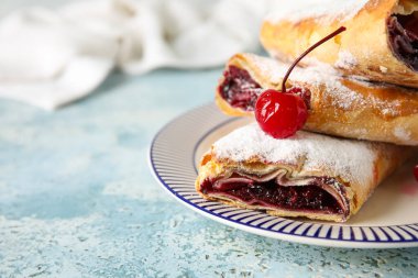 Açık mavi masada vişneli turta.