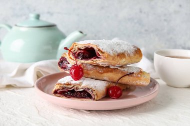 Tatlı vişneli turta ve beyaz arka planda bir fincan çay.