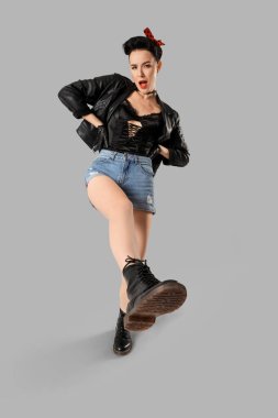 Deri ceketli, arka planda genç bir afiş kadın.