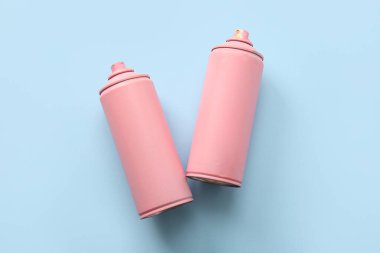 Mavi arka planda sprey boya kutuları