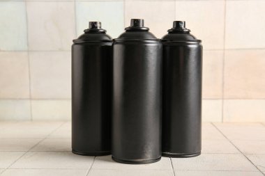 Fayans zemininde siyah sprey boya kutuları