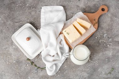 Taze tereyağlı kompozisyon, seramik tabak ve grunge arkaplanda süt