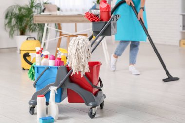 Ofiste tramvayı ve elektrikli süpürgesi olan bir temizlikçi.