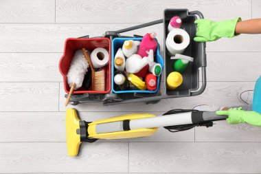 Temizlik malzemeleriyle yük arabası iten hademe, üst manzara.