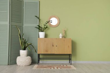 Ayna, klozet ve yeşil katlama ekranlı oturma odasının içi