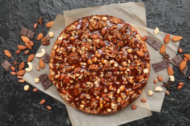 Farklı fındıklı tatlı tart kağıdı ve siyah zemin üzerinde karamel.