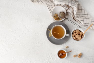 Beyaz arka planda bal ve şeker küplü bir fincan lezzetli ıhlamur çayı.